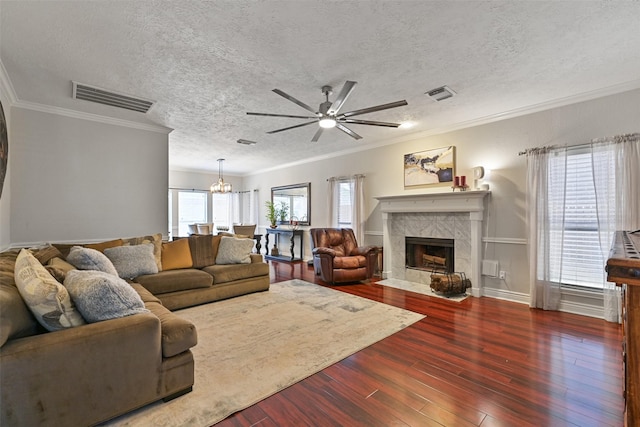 living room featuring a fireplace, wood finished floors, visible vents, and a textured ceiling