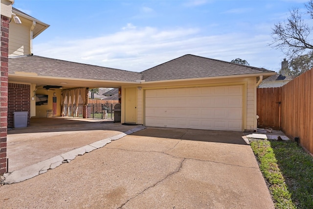 view of front of house with brick siding, roof with shingles, driveway, and fence