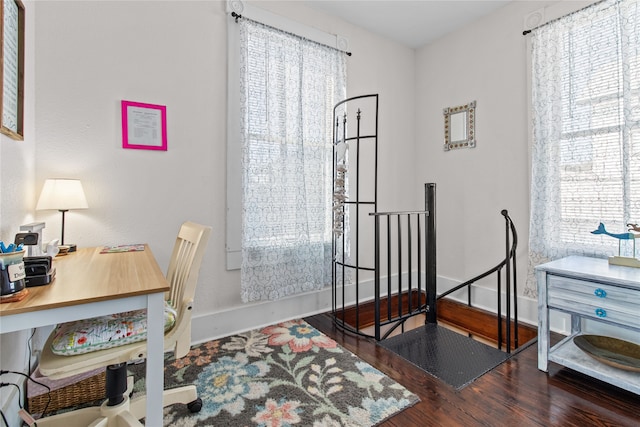 office area featuring baseboards, dark wood-style flooring, and a wealth of natural light