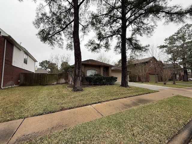 view of front of house featuring a garage, concrete driveway, a front lawn, and fence