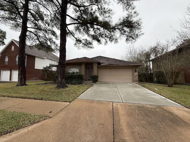 view of front facade featuring a garage, a front yard, brick siding, and driveway