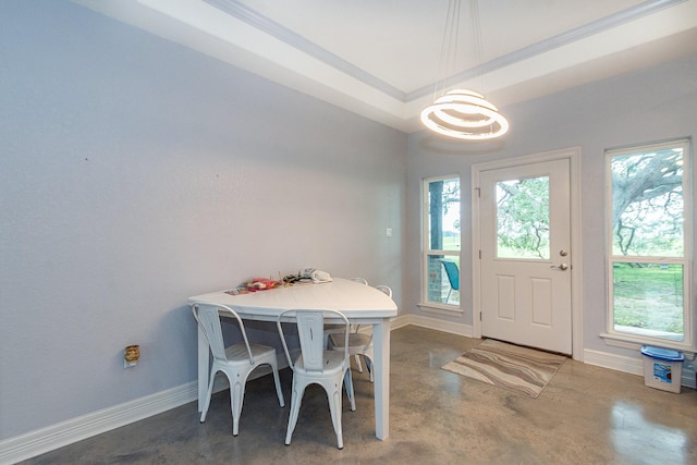 dining room with baseboards, a raised ceiling, and finished concrete floors