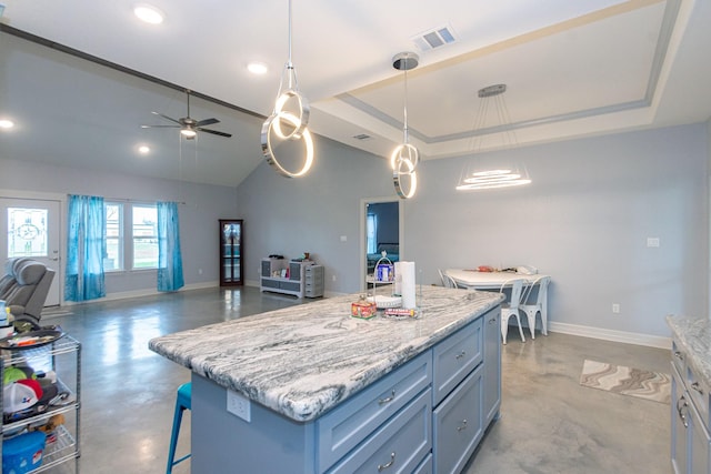 kitchen with pendant lighting, a center island, open floor plan, and a raised ceiling