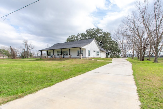 view of front of home with a garage, covered porch, driveway, and a front yard