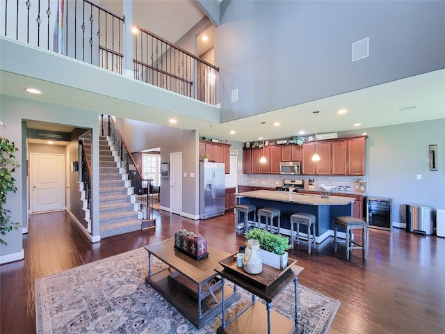 1904 Emerald Breeze Ct, Pearland, TX 77089 - living area with wine cooler, baseboards, a towering ceiling, and dark wood-style floors