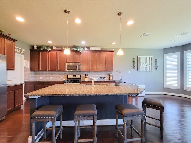1904 Emerald Breeze Ct, Pearland, TX 77089 - kitchen with decorative backsplash, dark wood-style floors, a breakfast bar, and stainless steel appliances