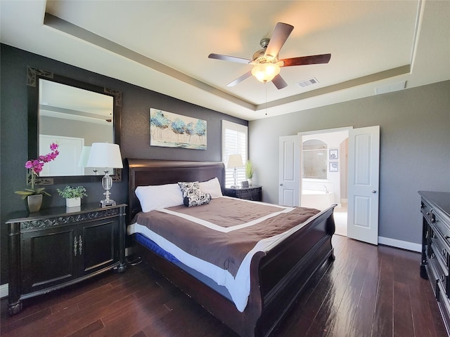 1904 Emerald Breeze Ct, Pearland, TX 77089 - bedroom with dark wood-style flooring, a tray ceiling, baseboards, and visible vents