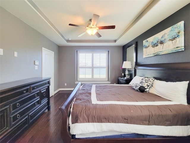 1904 Emerald Breeze Ct, Pearland, TX 77089 - bedroom featuring dark wood-style flooring, a tray ceiling, baseboards, and a ceiling fan