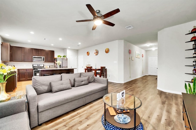 living area featuring recessed lighting, visible vents, light wood-style flooring, a ceiling fan, and baseboards