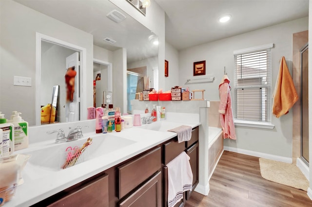 bathroom featuring a stall shower, visible vents, vanity, and wood finished floors