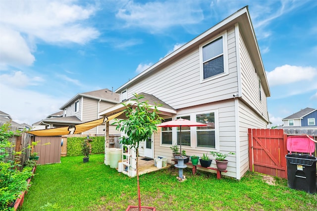 rear view of property with fence and a lawn