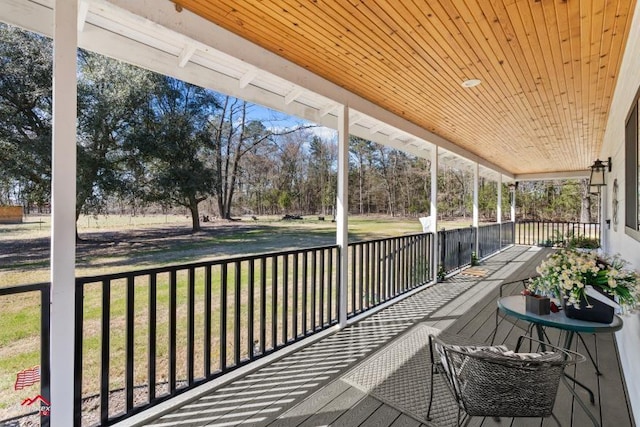 deck with covered porch and a yard