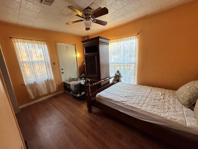 bedroom with visible vents, a ceiling fan, wood finished floors, baseboards, and access to exterior