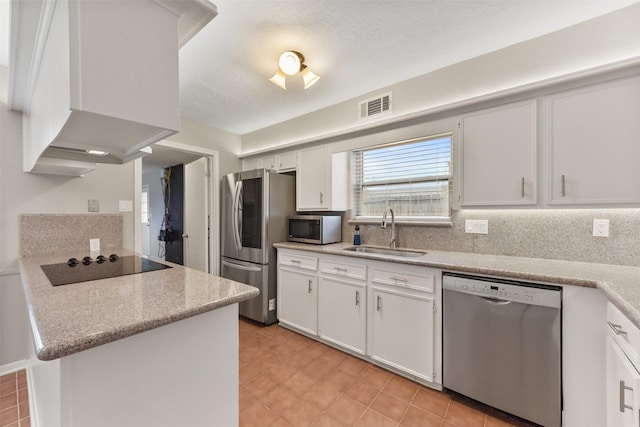 kitchen featuring stainless steel appliances, a sink, visible vents, and white cabinets