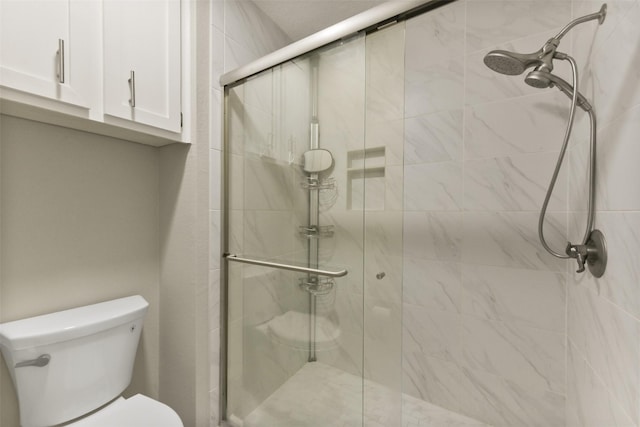 bathroom featuring a shower stall and toilet