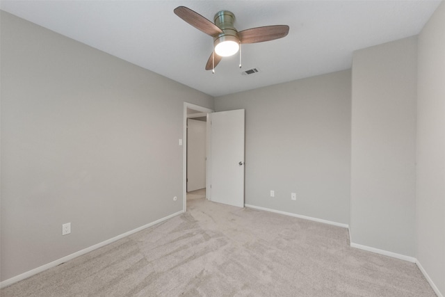 unfurnished room featuring light carpet, ceiling fan, visible vents, and baseboards