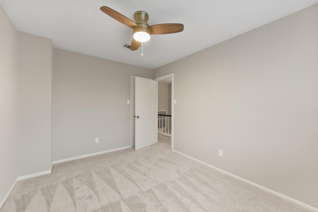 spare room with visible vents, baseboards, a ceiling fan, and light colored carpet