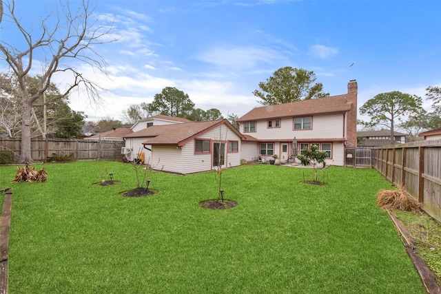 rear view of house featuring a fenced backyard, a chimney, a patio, and a yard