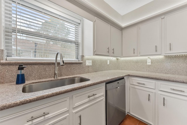 kitchen with dishwasher, backsplash, light countertops, white cabinetry, and a sink