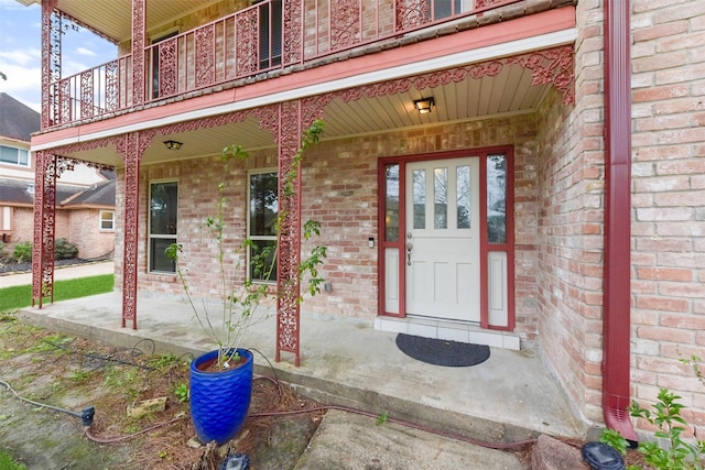 property entrance with brick siding and a porch