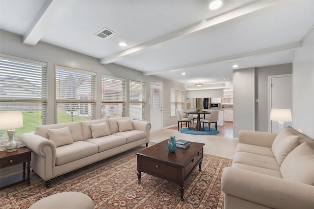 living area with recessed lighting, visible vents, and beamed ceiling