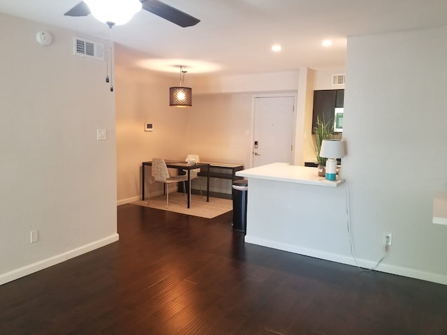 kitchen featuring dark wood-type flooring, visible vents, baseboards, light countertops, and pendant lighting