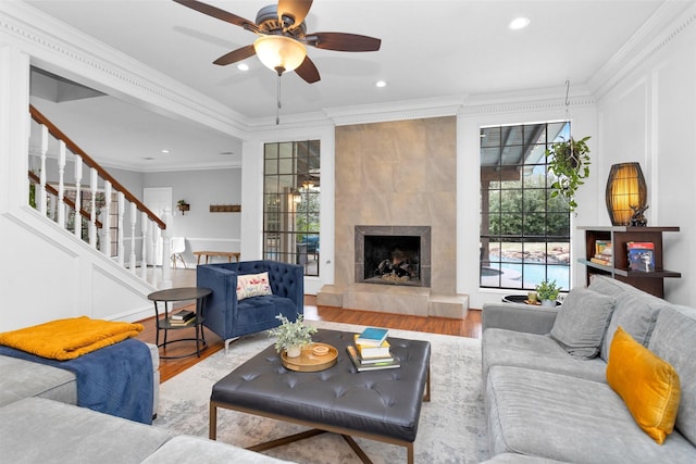 8014 Northbridge Cir, Spring, TX 77379 - living area with wood finished floors, crown molding, ceiling fan, stairway, and a tile fireplace