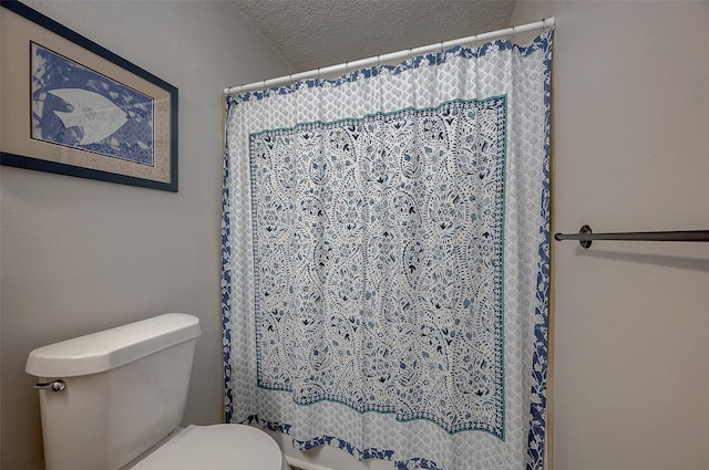 full bathroom with toilet, a textured ceiling, and a shower with shower curtain