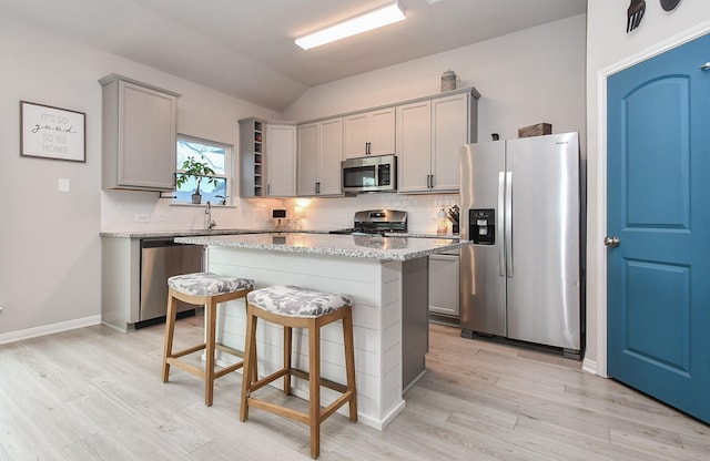 915 Acorn Trail Pl, Tomball, TX 77375 - kitchen with stainless steel appliances, gray cabinetry, lofted ceiling, open shelves, and decorative backsplash