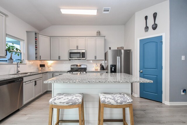 915 Acorn Trail Pl, Tomball, TX 77375 - kitchen featuring stainless steel appliances, a sink, decorative backsplash, gray cabinets, and lofted ceiling