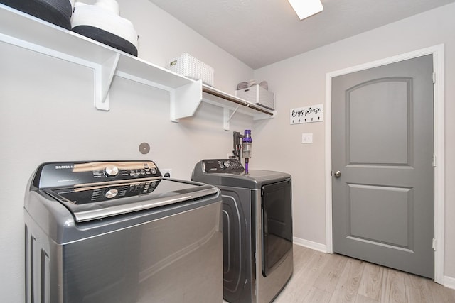 915 Acorn Trail Pl, Tomball, TX 77375 - laundry area featuring washer and dryer, light wood-style flooring, and baseboards