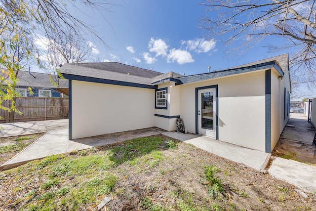 back of property with a patio area, stucco siding, and fence