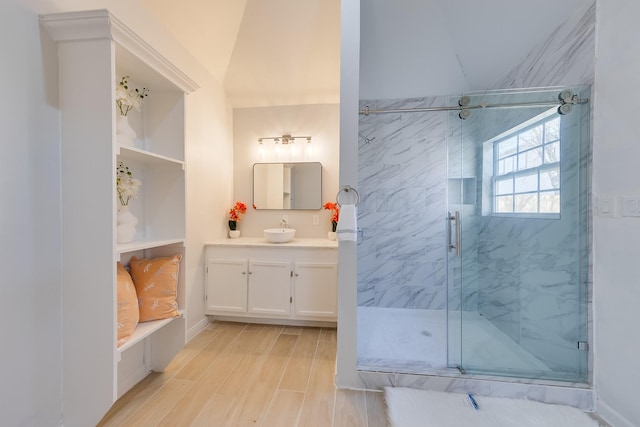 full bath featuring a marble finish shower, vanity, and wood finished floors