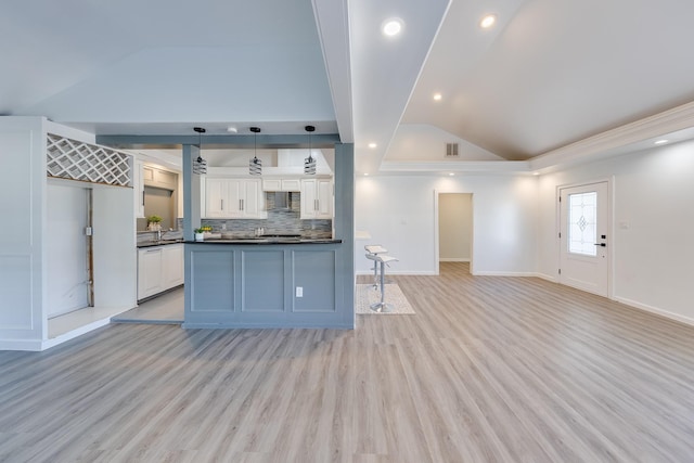 kitchen featuring exhaust hood, white cabinets, open floor plan, hanging light fixtures, and dark countertops