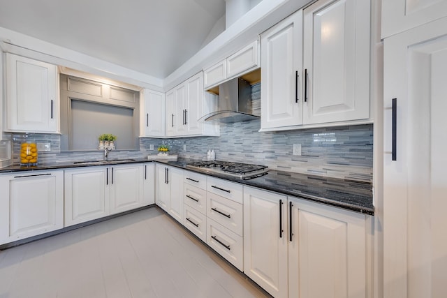 kitchen with white cabinetry, stainless steel gas stovetop, wall chimney exhaust hood, and a sink