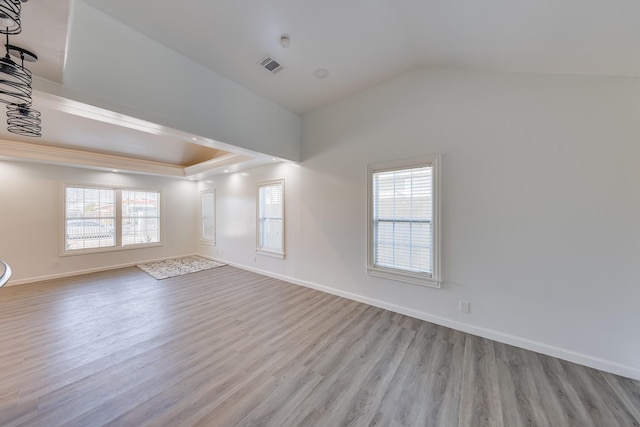 empty room featuring visible vents, baseboards, a healthy amount of sunlight, and wood finished floors