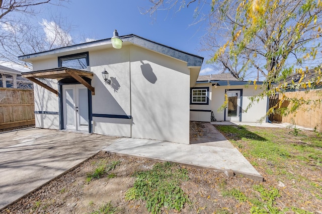 exterior space with a patio, fence, and stucco siding