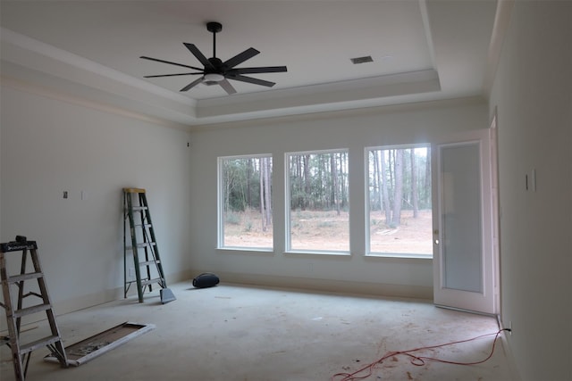 spare room with baseboards, a tray ceiling, and a ceiling fan