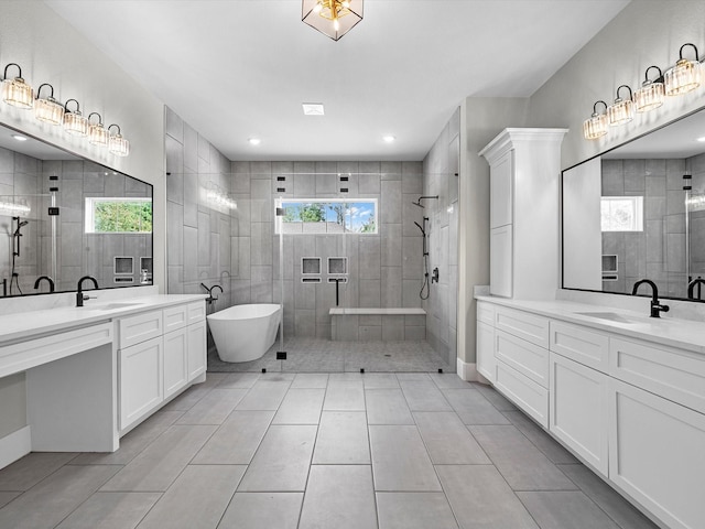 full bath featuring tile patterned floors, two vanities, a sink, and a walk in shower