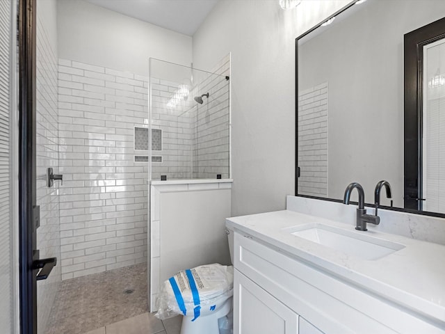 bathroom featuring a walk in shower, toilet, and vanity