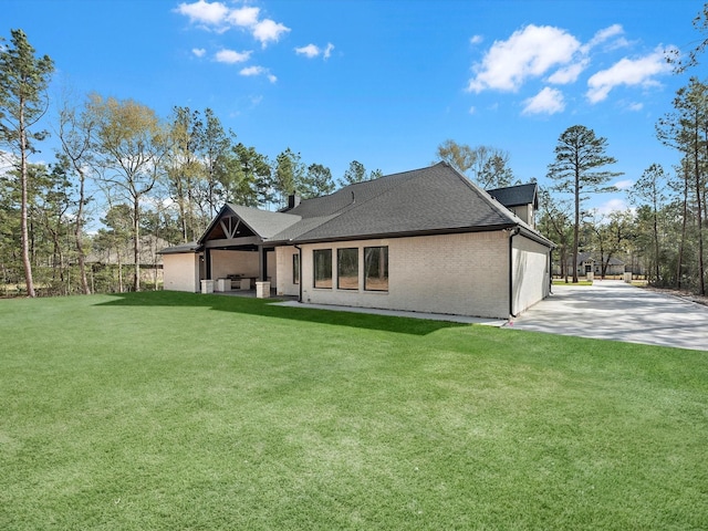15681 Connie Ln, Montgomery, TX 77316 - back of house featuring a patio area, a lawn, brick siding, and roof with shingles