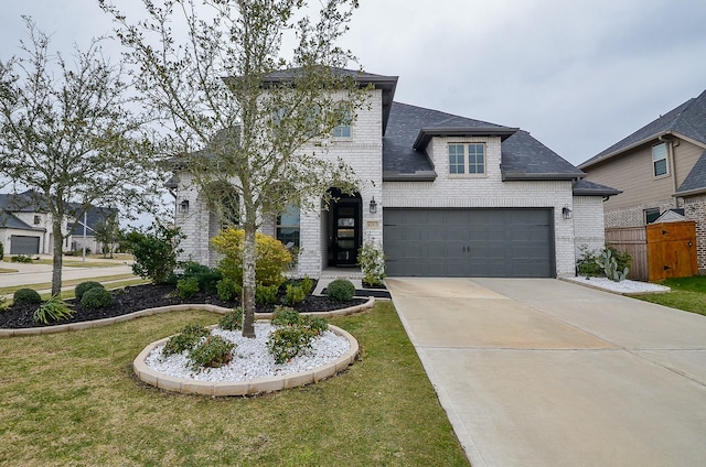 french country home featuring driveway, brick siding, a front lawn, and an attached garage