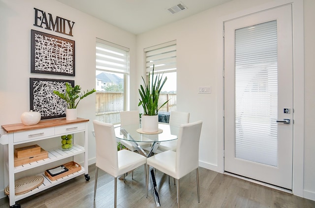 dining area with wood finished floors, visible vents, and baseboards