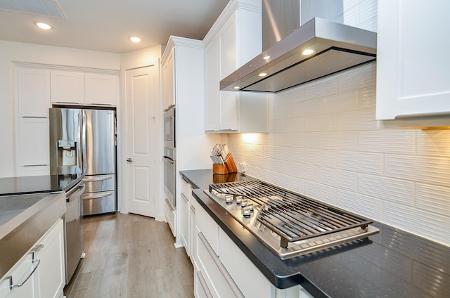 kitchen with visible vents, appliances with stainless steel finishes, exhaust hood, and white cabinetry