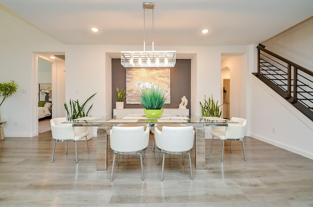 dining room featuring arched walkways, stairway, wood finished floors, and recessed lighting