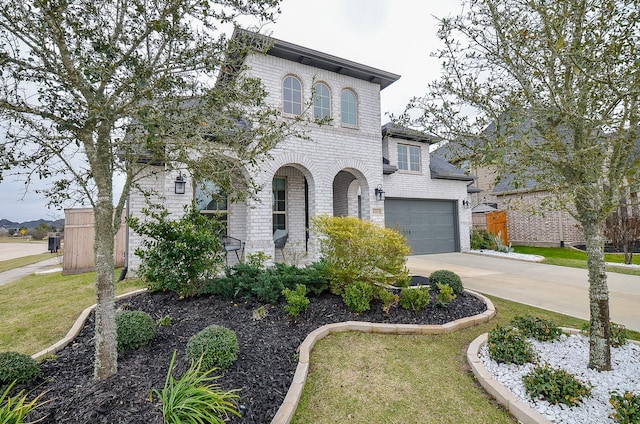 view of front of home featuring an attached garage, a front lawn, concrete driveway, and brick siding