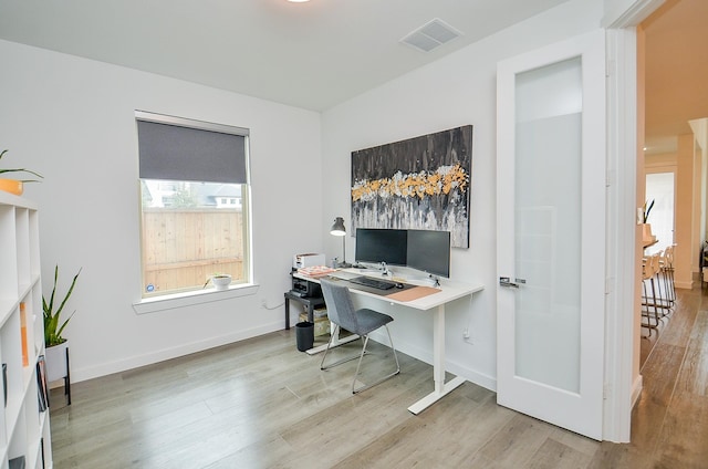 office space featuring visible vents, light wood-style flooring, and baseboards