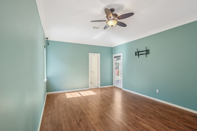 spare room featuring crown molding, wood finished floors, baseboards, and ceiling fan