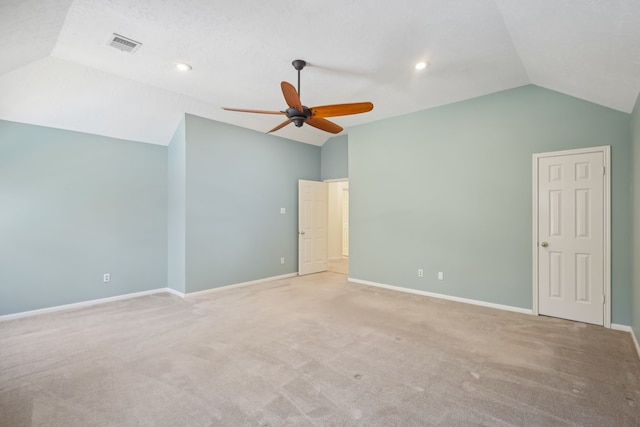 interior space featuring vaulted ceiling, light colored carpet, visible vents, and baseboards