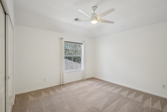 unfurnished room featuring baseboards, visible vents, a ceiling fan, and carpet